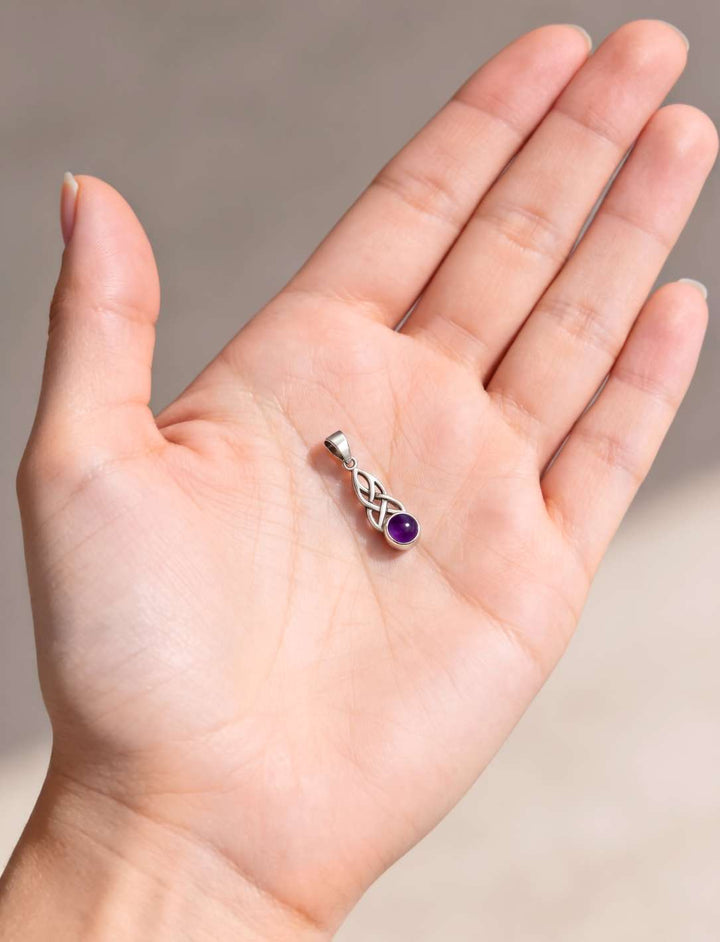 Größenvergleich: kleiner Silberanhänger mit Amethyst liegt in einer geöffneten Handfläche