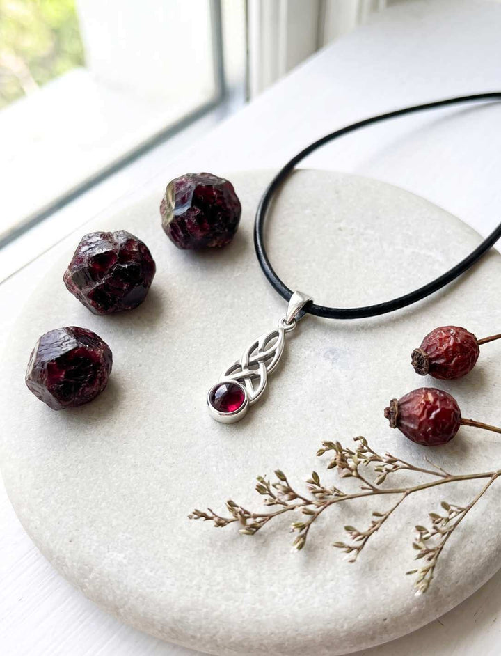 Granat Anhänger im Flatlay mit Granatperlen und Zweig