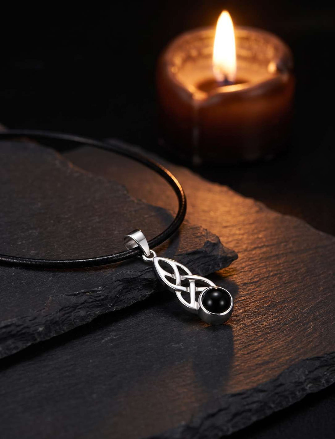 Keltischer Knoten Anhänger mit Onyx am Lederband bei Kerzenlicht