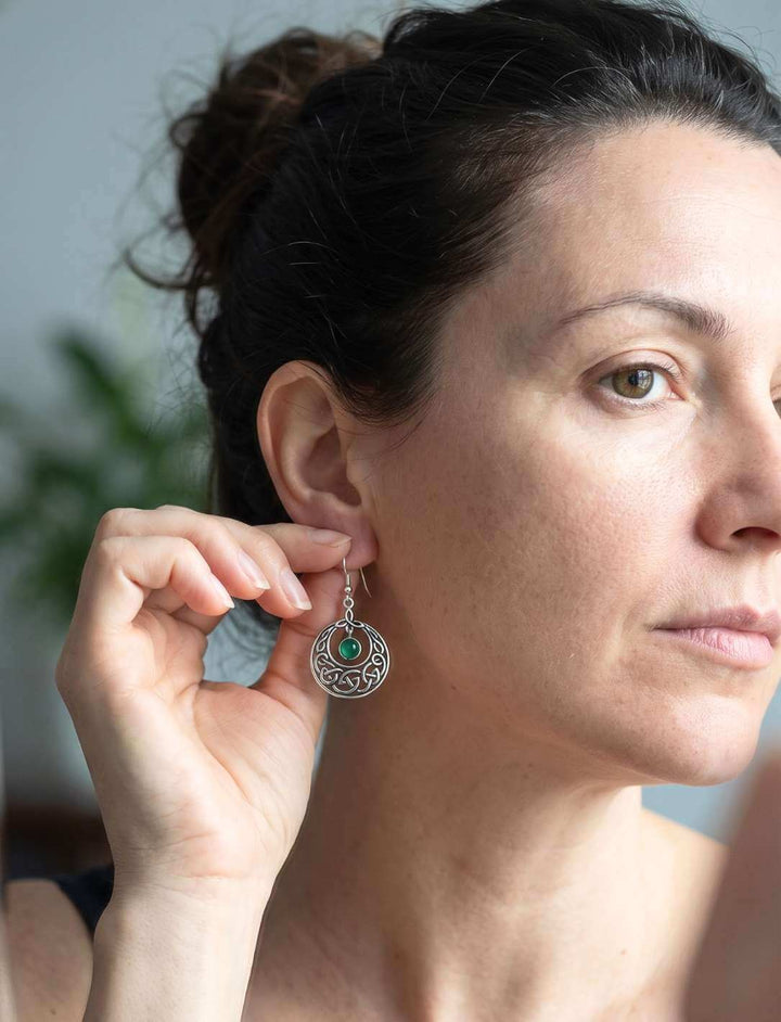 Frau legt Grünen Achat Ohrhänger Silber vor dem Spiegel an