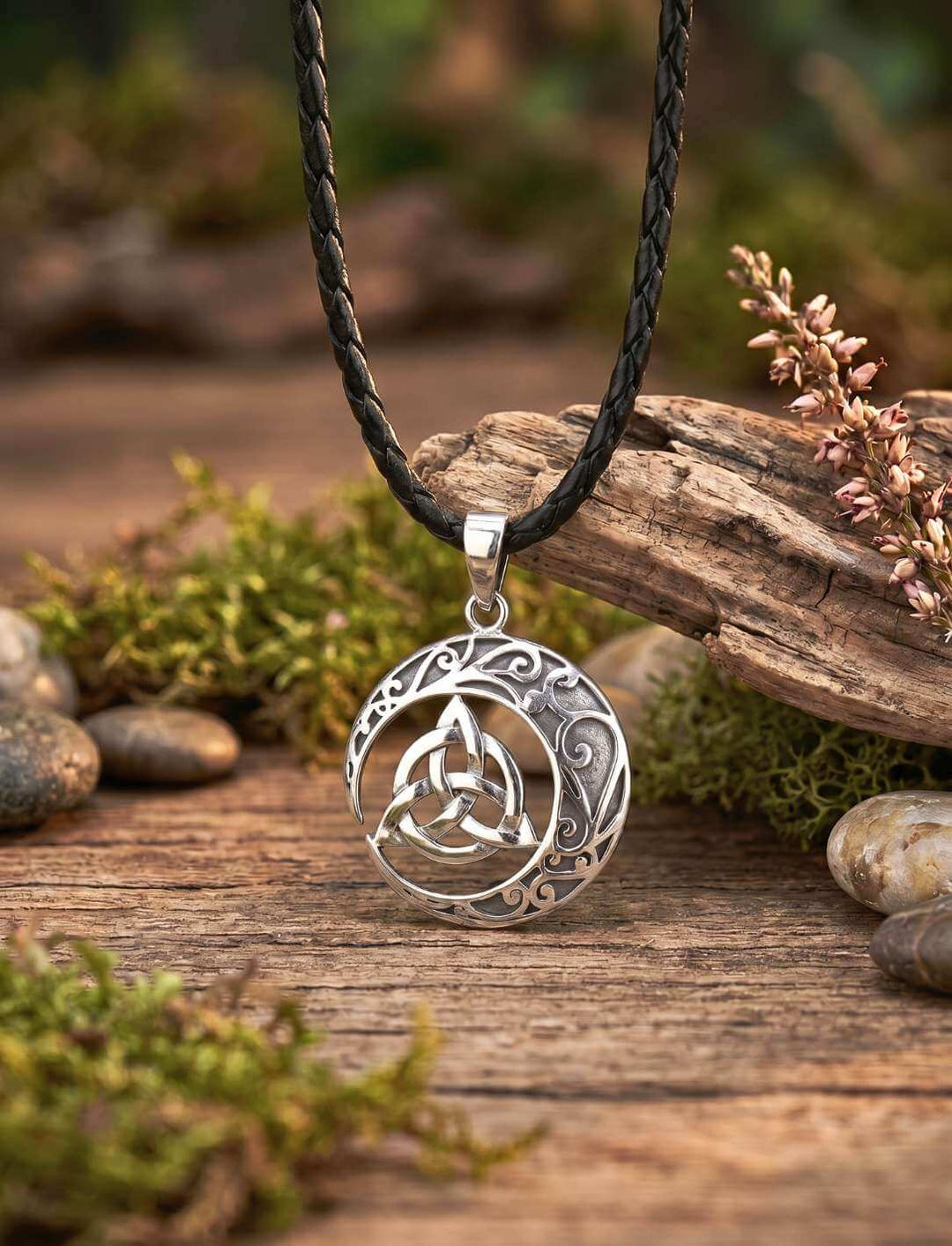 Keltischer Knoten Anhänger versilbert auf Holztisch mit Steinen