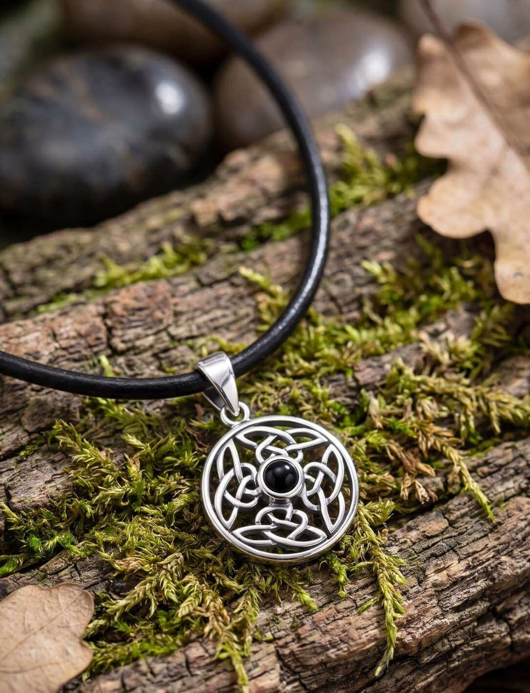 Keltischer Knoten Anhänger mit schwarzem Onyx an Lederkette auf verwittertem Holz
