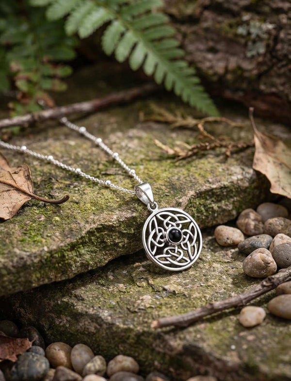 Silber Anhänger mit Onyx und keltischem Knotenmotiv auf bemoosten Steinen