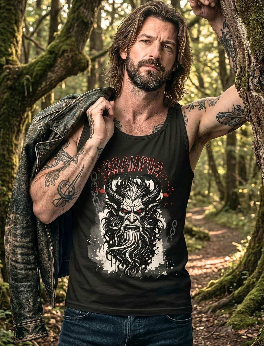 Mann mit Tattoos, Lederjacke, trägt das schwarze Krampus-Tanktop im Wald