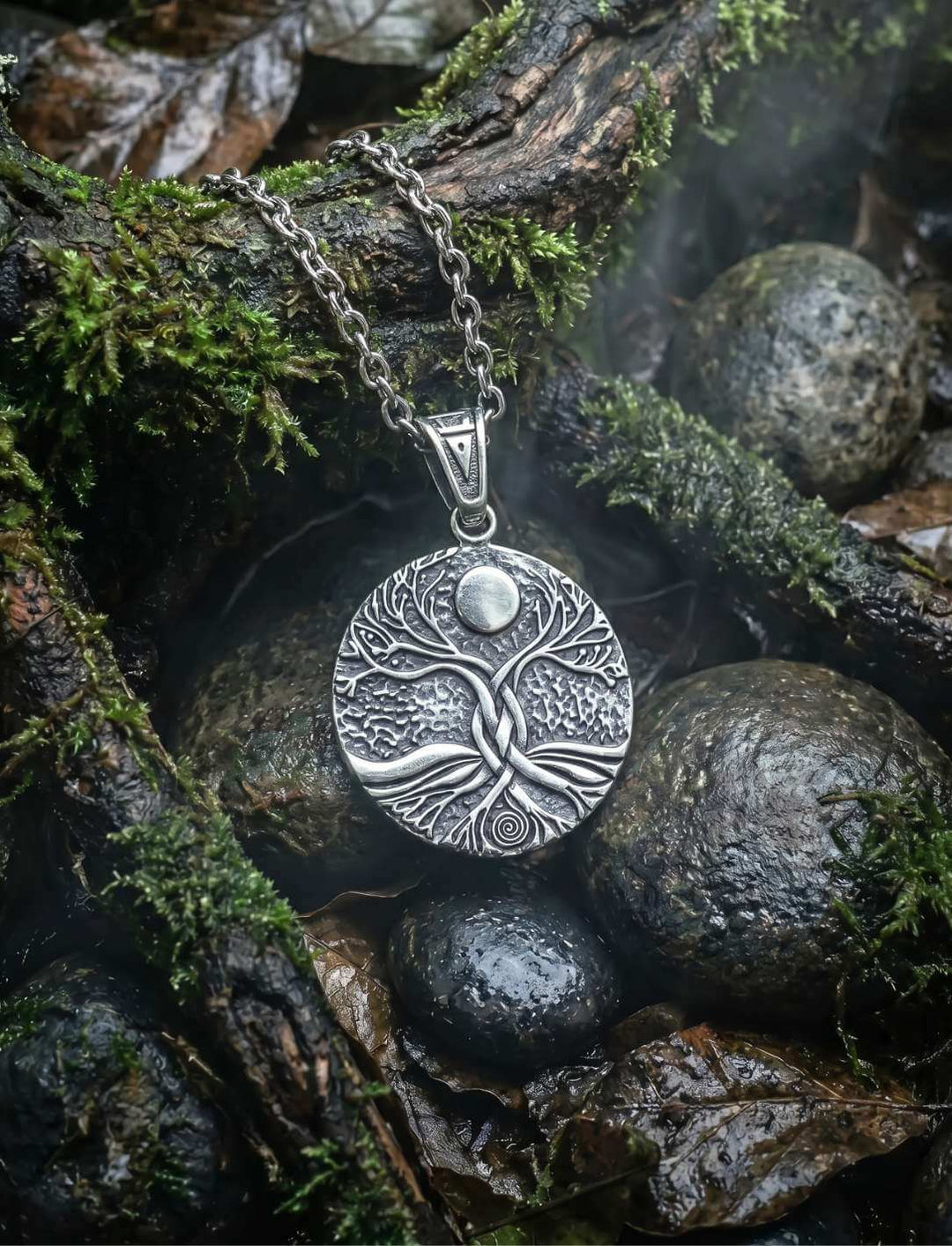 Lebensbaum Kette aus Edelstahl Pforte der alten Spirale mit Vollmond und Spiralmotiv auf dunklen Steinen im Wald
