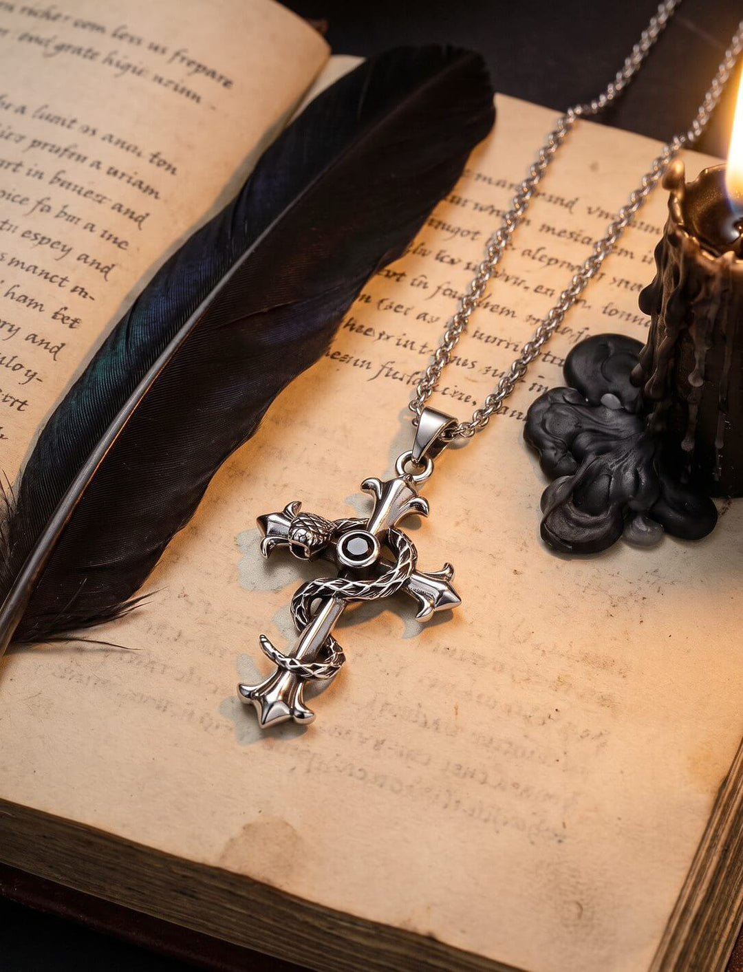 Lilienkreuz der Weisheit: Kreuz Anhänger mit Schlange und schwarzem Zirkonia an silberner Ankerkette auf altem Buch