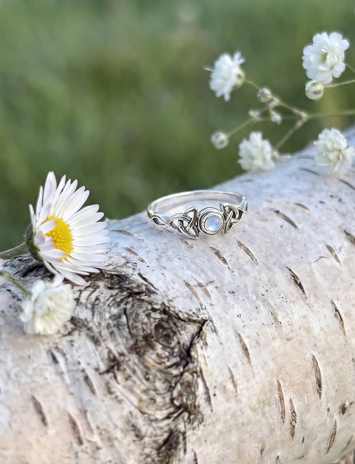Maitau von Bealtaine: Mondstein Ring aus Silber mit zwei Triquetras auf einem Birkenstamm mit Gänseblümchen
