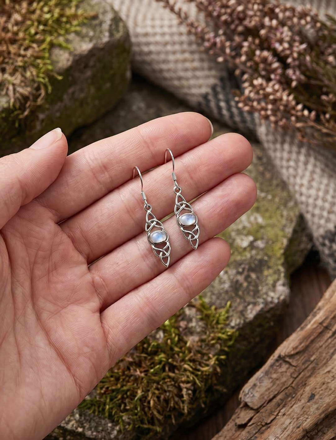 Mondpfad des keltischen Knotens Silber Ohrhänger in der Hand als Größenvergleich
