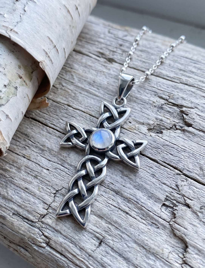 Silberkreuz mit Mondstein an feiner Perlenkette aus 925 Sterling Silber auf hellem Treibholz