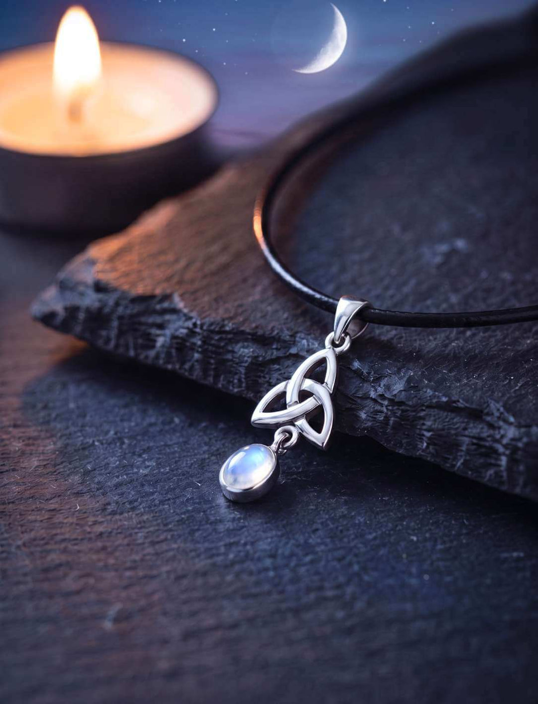 Keltischer Triquetra Anhänger mit Regenbogenmondstein am Lederband auf dunklem Schiefer