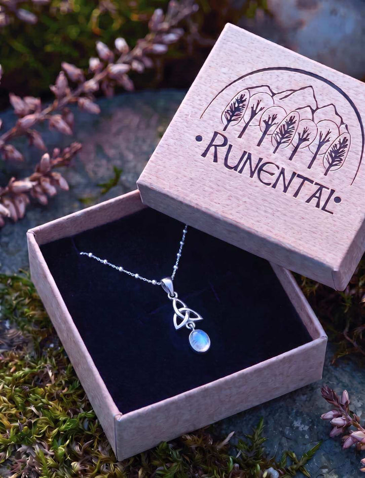 Mondstein Anhänger in einer geöffneten Runental Geschenkbox aus Holz auf Heidekraut