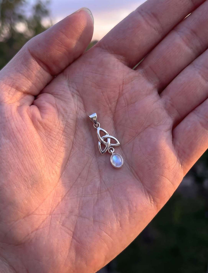 Größenvergleich: der kleine Triquetra Anhänger mit Mondstein liegt in einer geöffneten Handfläche