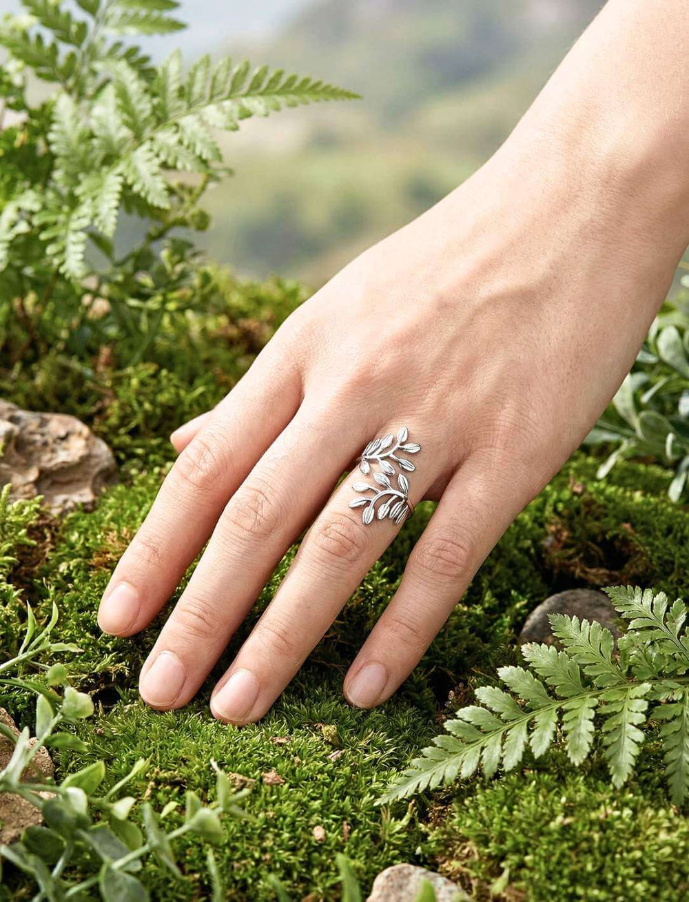 Nemeton Blätterring aus Edelstahl an Hand im Moos mit Farnen