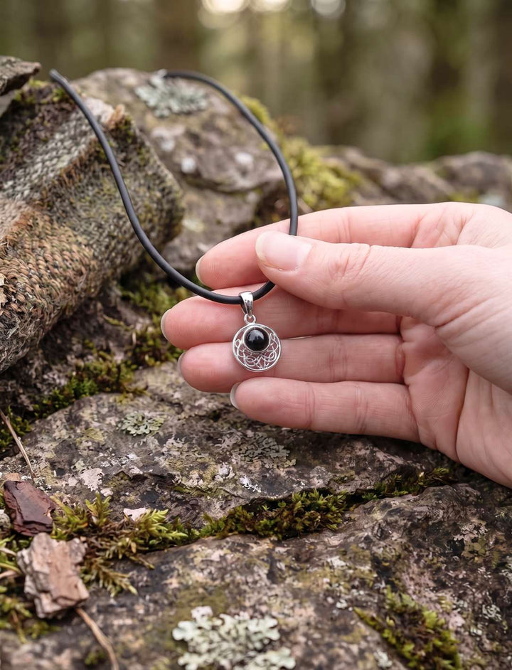 Onyx Anhänger an Lederkette in der Hand, zeigt die tatsächliche Größe