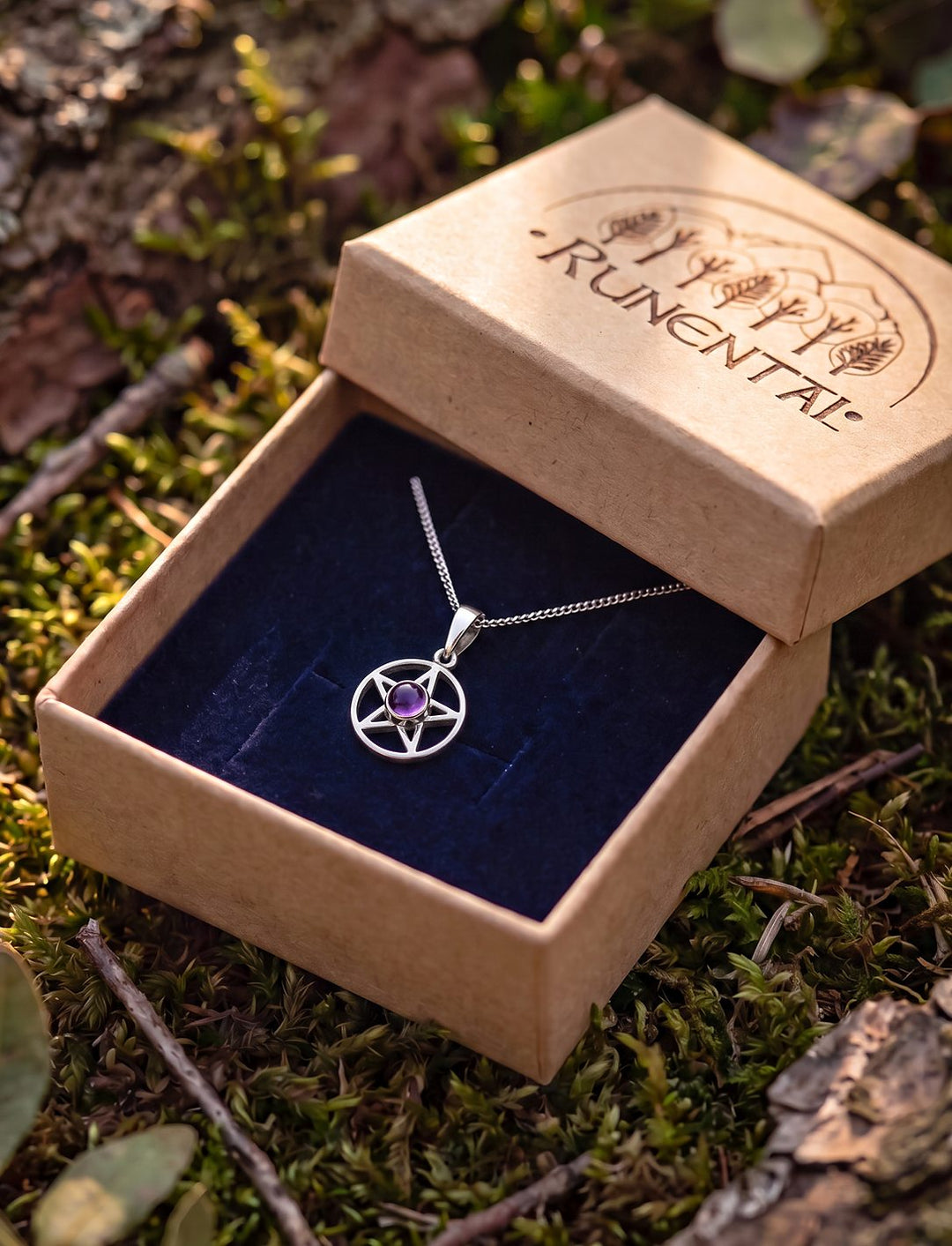 Pentagramm Kette mit Amethyst an feiner Silberkette in der geöffneten Runental Geschenkbox auf Waldmoos im Abendlicht