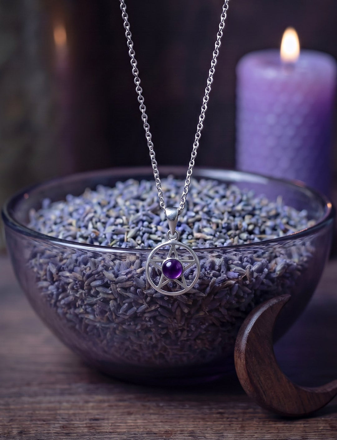 Fünfzackiger Stern im Kreis aus 925 Silber mit Amethyst an Silberkette über einer Glasschale mit Lavendel und hölzerner Mondsichel