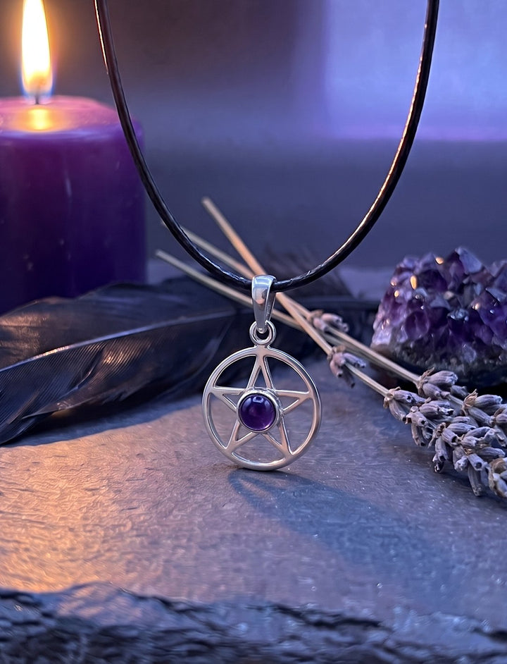 Dämmerstern: Pentagramm Kette aus Silber mit Amethyst an schwarzer Lederkordel auf Schiefer neben Lavendel und violetter Kerze