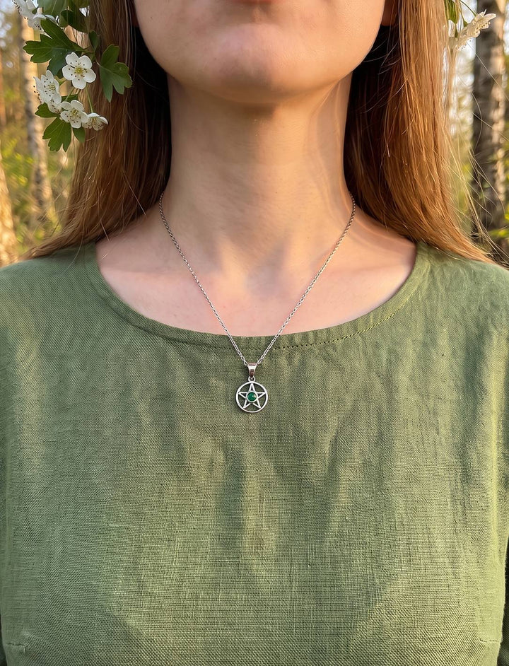 Frau mit Weißdornkranz und grünem Leinenkleid trägt den Pentakel Anhänger mit Achat an feiner Silberkette im Birkenwald