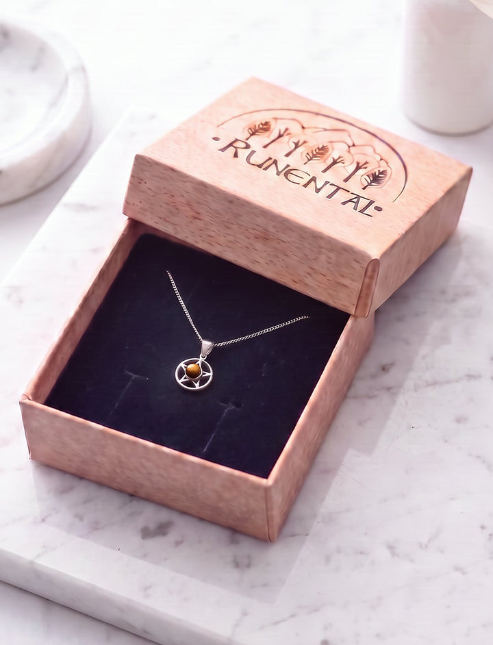 Pentagramm Kette mit Tigerauge an Silberkette in der geöffneten Runental Geschenkbox auf weißem Marmor