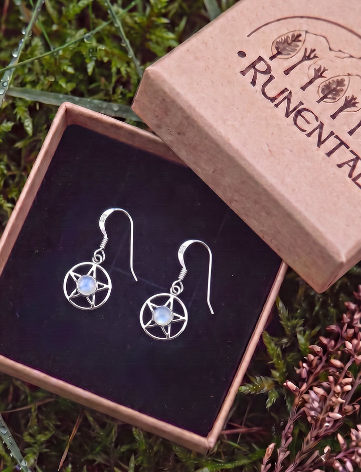 Pentagramm Ohrringe mit Regenbogenmondstein in der geöffneten Runental Geschenkbox auf Moos mit Heidekraut