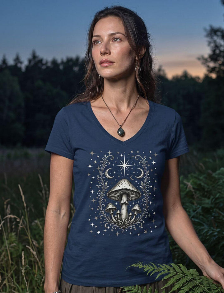 Frau zwischen Farn trägt dunkelblaues V-Neck Shirt mit hellem Pilzmotiv