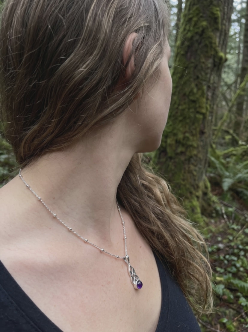 Video: Frau im Wald trägt den keltischen Silberanhänger mit Amethyst, der Stein fängt das Licht
