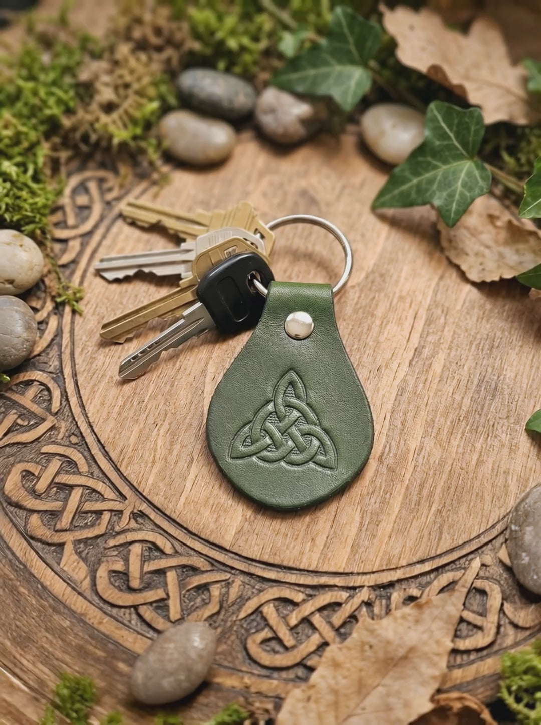 Video von Grüner Rindsleder Schlüsselanhänger mit keltischem Trinity Knot in natürlicher Umgebung