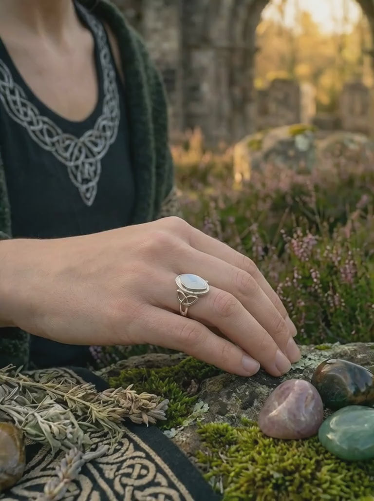 Keltischer Mondsteinring aus Sterling Silber mit Triquetra auf Moos und Holz