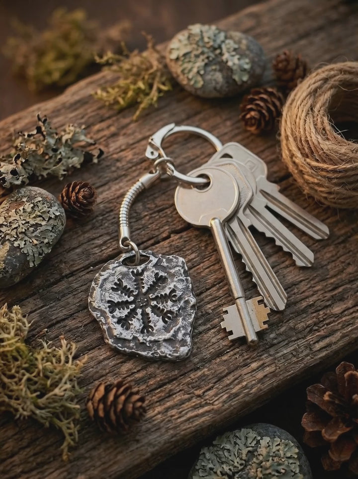 Video: Aegishjálmur Schlüsselanhänger mit isländischem Runenkreis, gezeigt in ruhiger Bewegung im natürlichen Umfeld