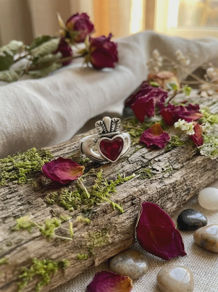 Claddagh Ring aus Silber mit rotem Zirkonia in keltischer Waldszene aus verschiedenen Perspektiven