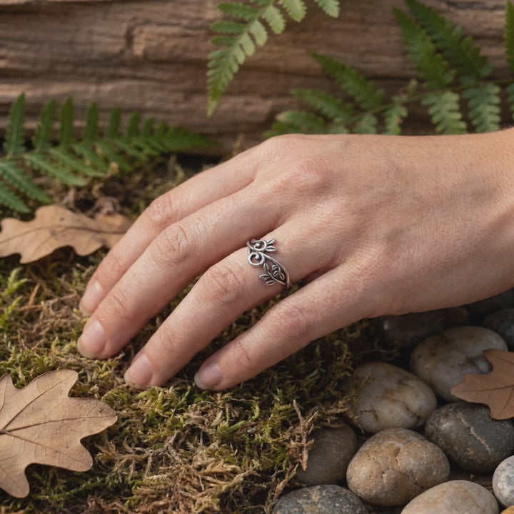 Video Naturinspirierter Silberring mit floralen Blättern in Natursetting an Frauenhand.