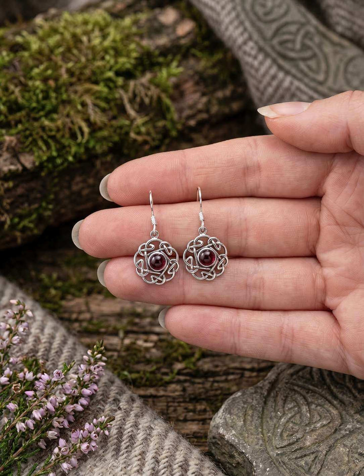 Rote Blüte des keltischen Knotens Silber Ohrhänger in der Hand als Größenvergleich