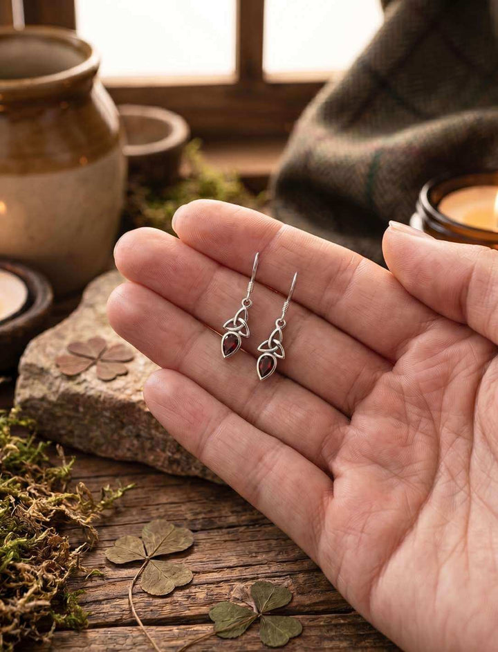 Rote Glut der Triquetra Silber Ohrhänger in der Hand als Größenvergleich