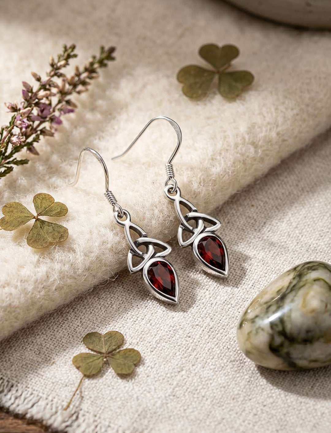 Rote Glut der Triquetra Silber Ohrhänger auf hellem Stoff mit Kleeblättern