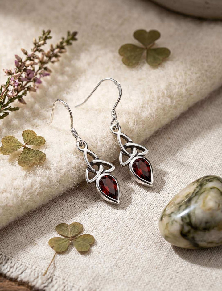 Rote Glut der Triquetra Silber Ohrhänger auf hellem Stoff mit Kleeblättern