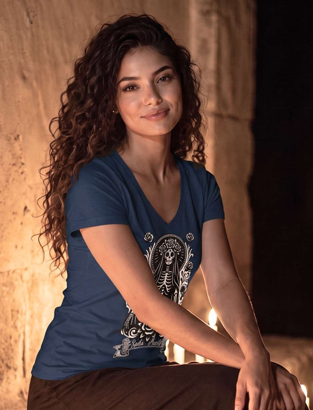 Damen V-Neck Shirt in Navy, sitzend an einer alten Steinmauer bei Kerzenlicht