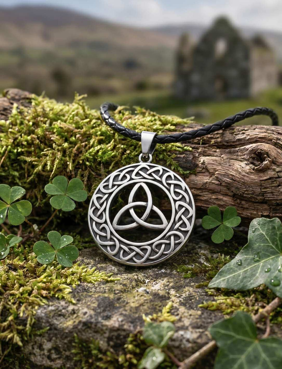Schild des Druiden Anhänger auf Moos mit Kleeblatt, irische Ruinen im Hintergrund