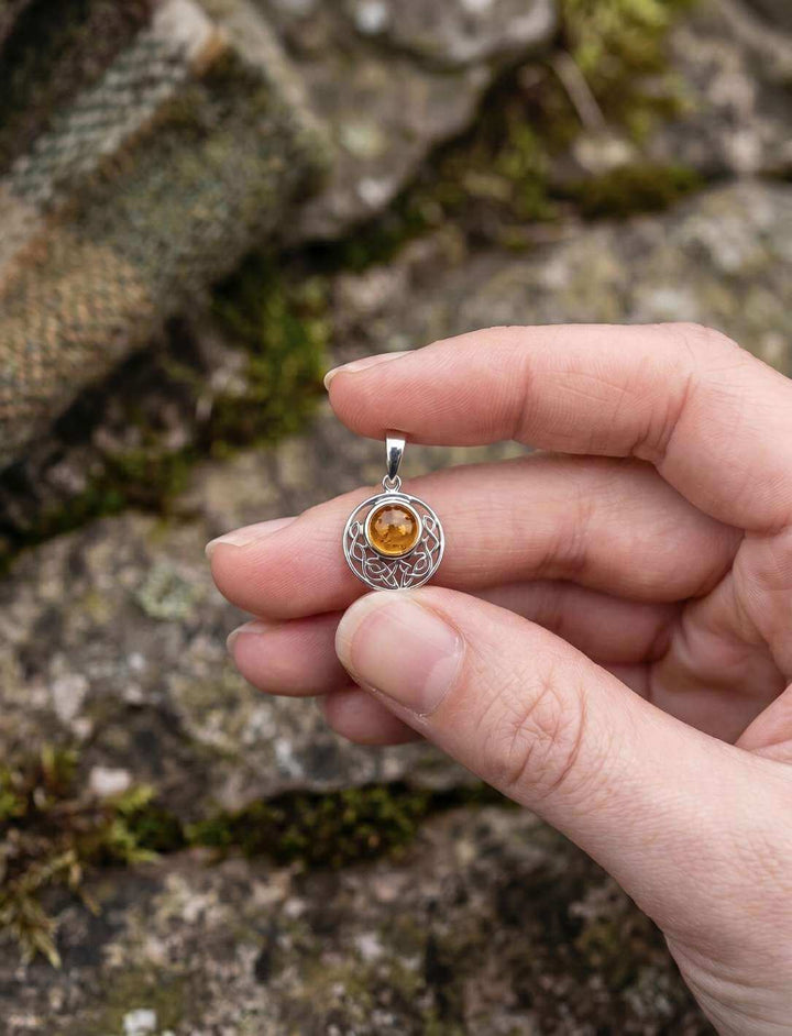 Keltischer Knoten Anhänger mit Bernstein in der Hand – Größenverhältnis 16 mm