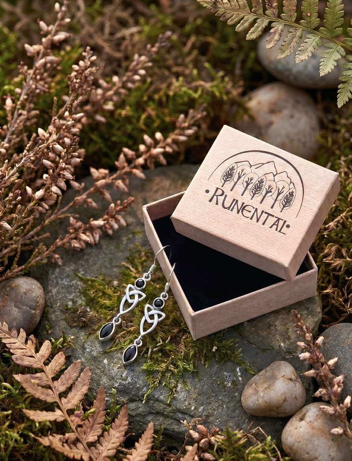 Schwarze Triquetra Silber Ohrhänger mit Onyx neben geöffneter Schmuckbox