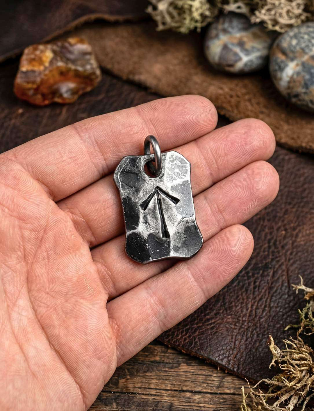 Schwur des Tyr, geschmiedete Tiwaz Rune, in der Hand gehalten zum Groessenvergleich.