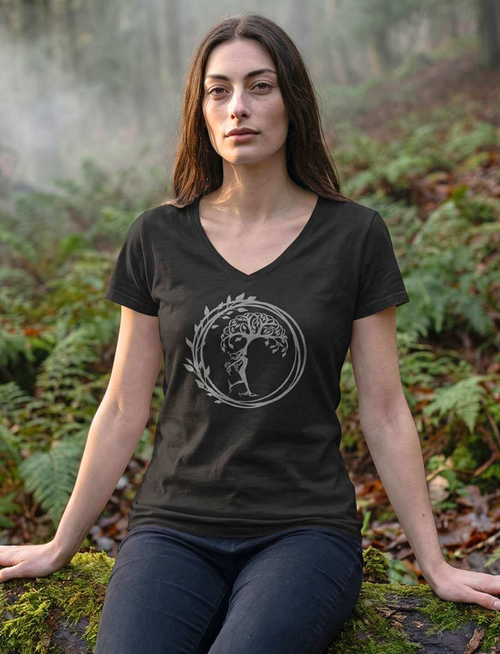 Schwarzes Damen Shirt mit V-Ausschnitt, sitzend auf moosbewachsenem Waldboden