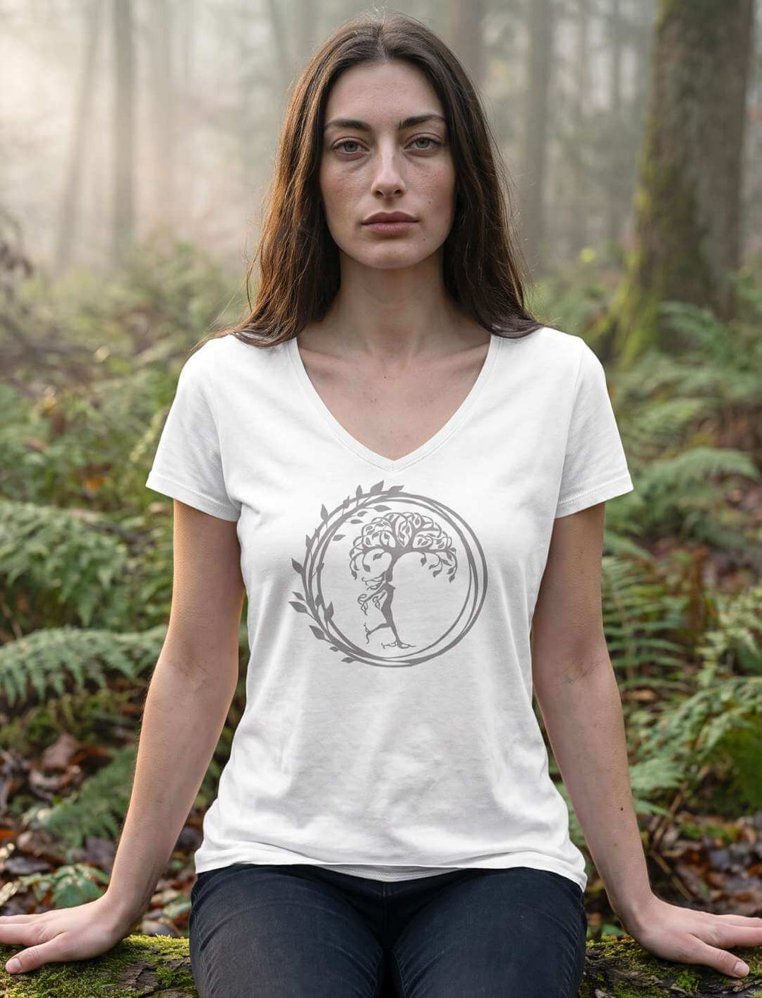 Frau im weissen Shirt sitzend zwischen Farn, Baummotiv im Kreis mittig auf der Brust
