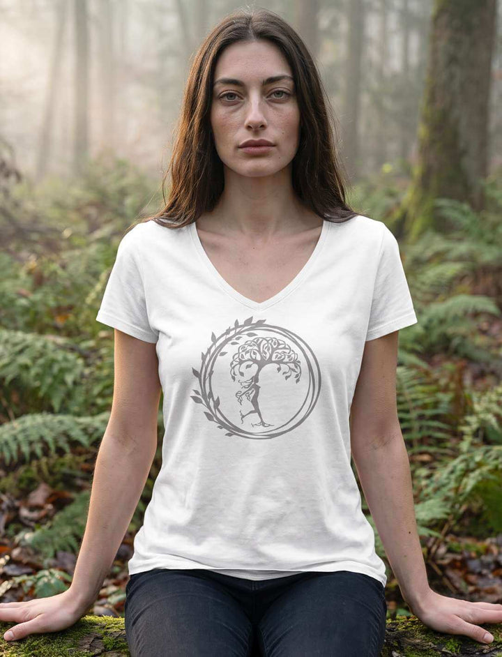 Frau im weissen Shirt sitzend zwischen Farn, Baummotiv im Kreis mittig auf der Brust