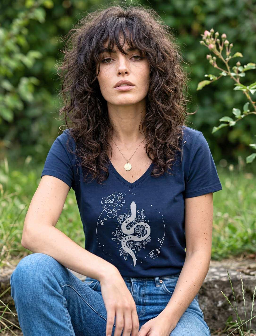 Damen V-Neck in Navy mit Schlange und Blüten, sitzend im sommerlichen Garten