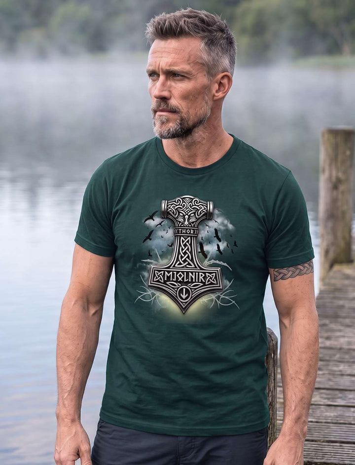 Mann in dunkelgrünem T-Shirt steht auf einem Holzsteg, Nebel über dem Wasser, Blick zur Seite