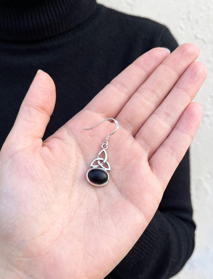 Onyx Ohrhänger mit keltischem Knoten in einer Handfläche als Größenvergleich