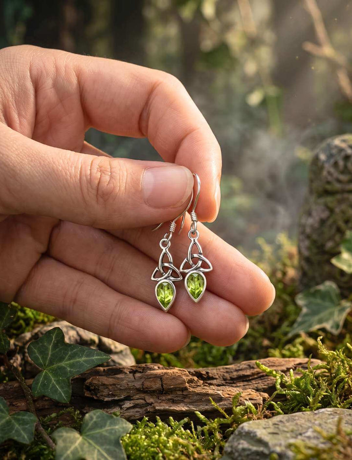 Triquetra Ohrhänger Peridot in der Hand als Größenvergleich