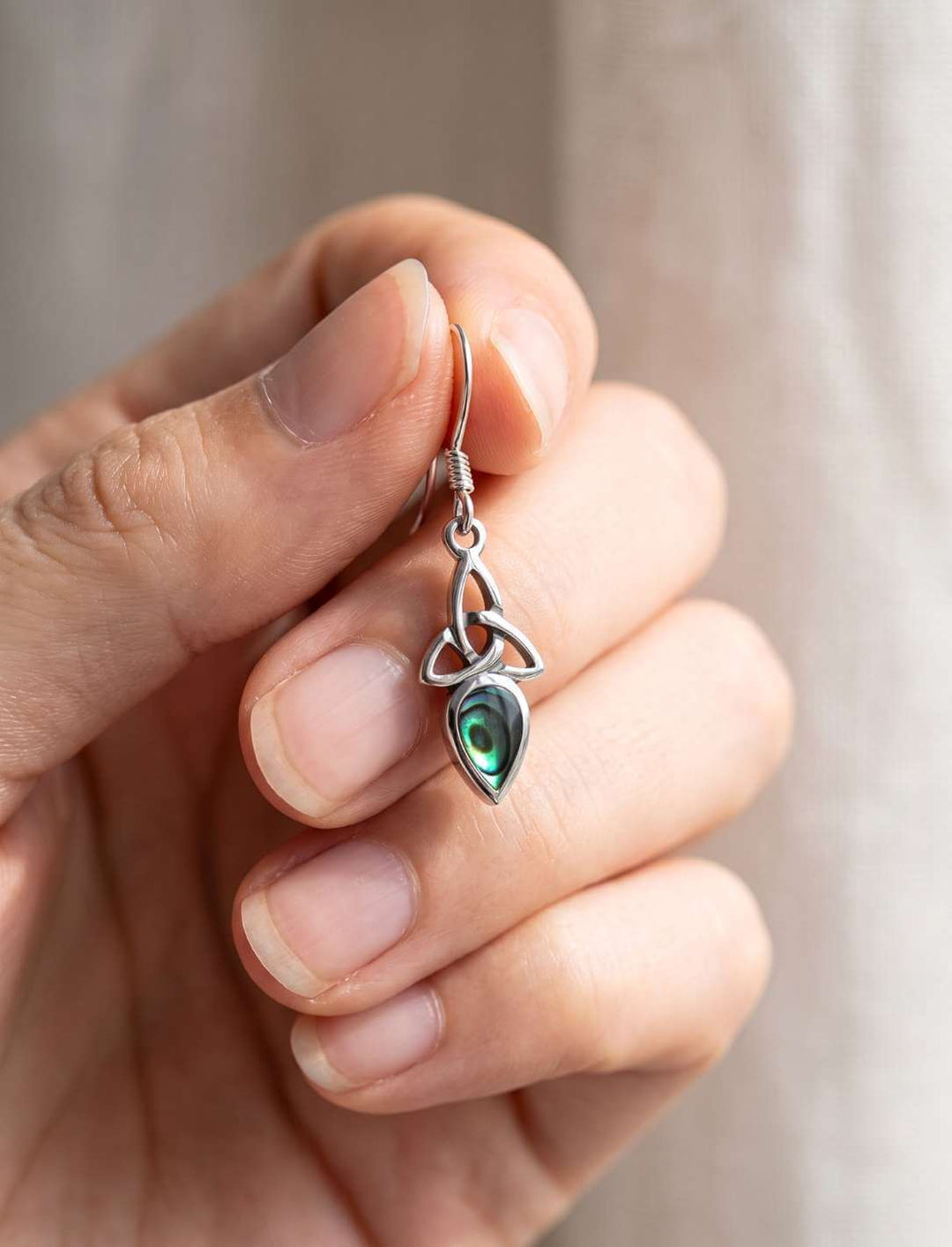 Triquetra Ohrhänger Perlmutt in der Hand als Größenvergleich