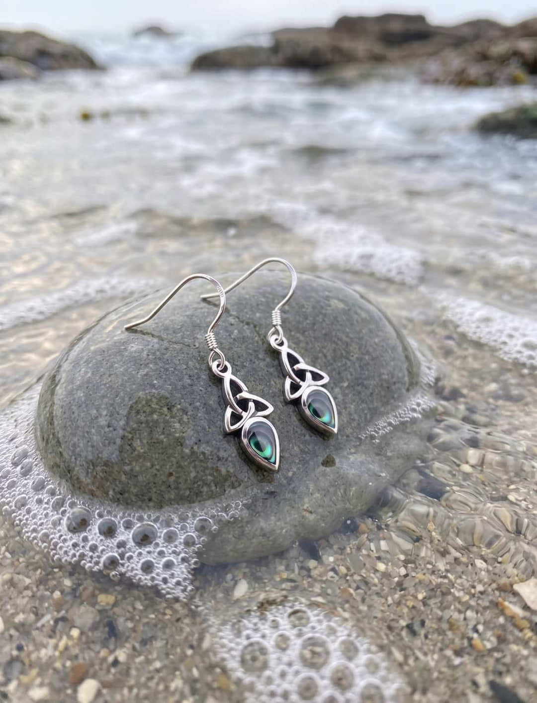 Triquetra Ohrhänger Silber mit Perlmutt auf Fels am Meer