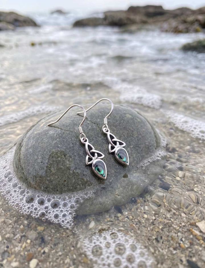 Triquetra Ohrhänger Silber mit Perlmutt auf Fels am Meer